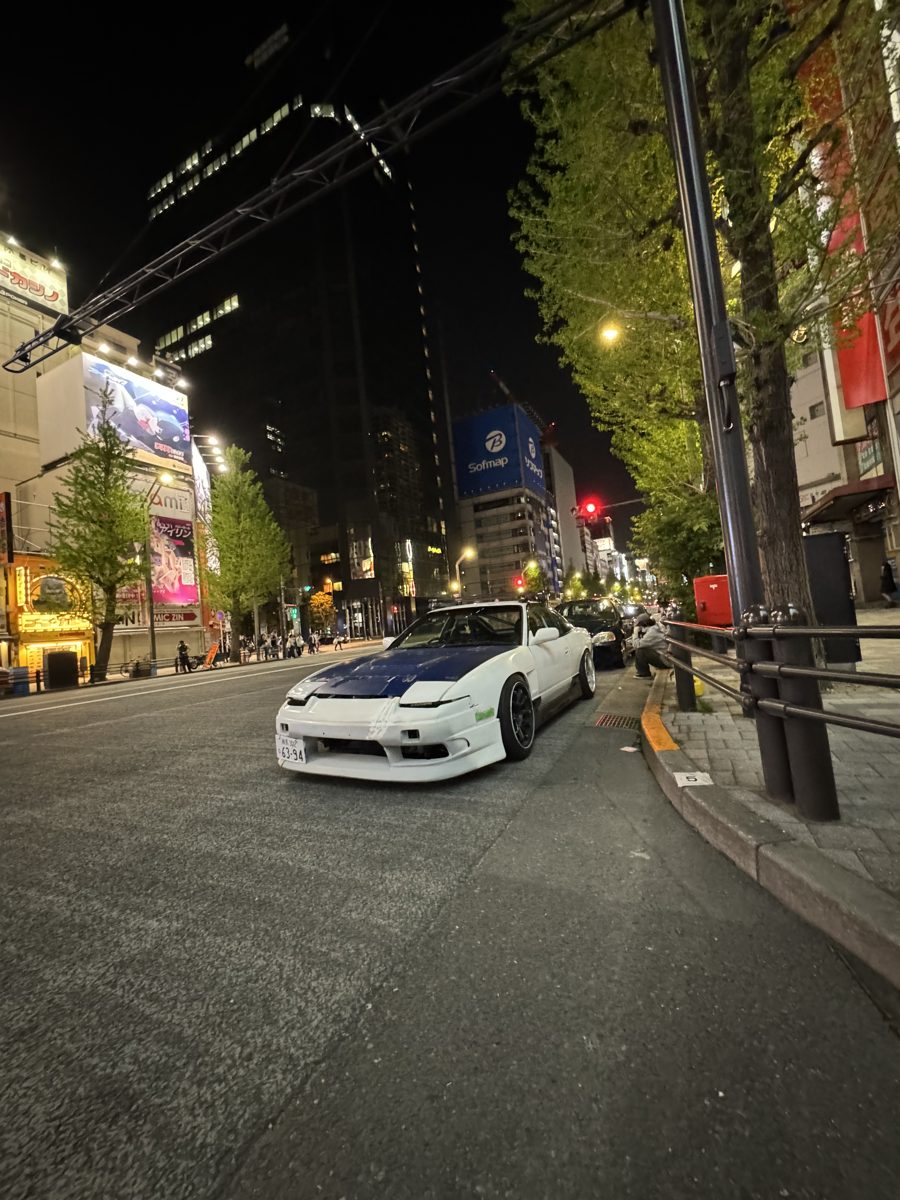 White Nissan 180SX with a blue hood parked on an Akihabara street at night