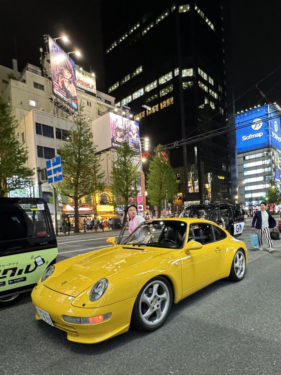 Speed yellow air-cooled Porsche 911 (993) in Akihabara night traffic