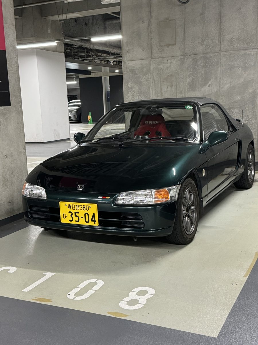 Green Honda Beat with a red Bride bucket seat in a Tokyo parking garage