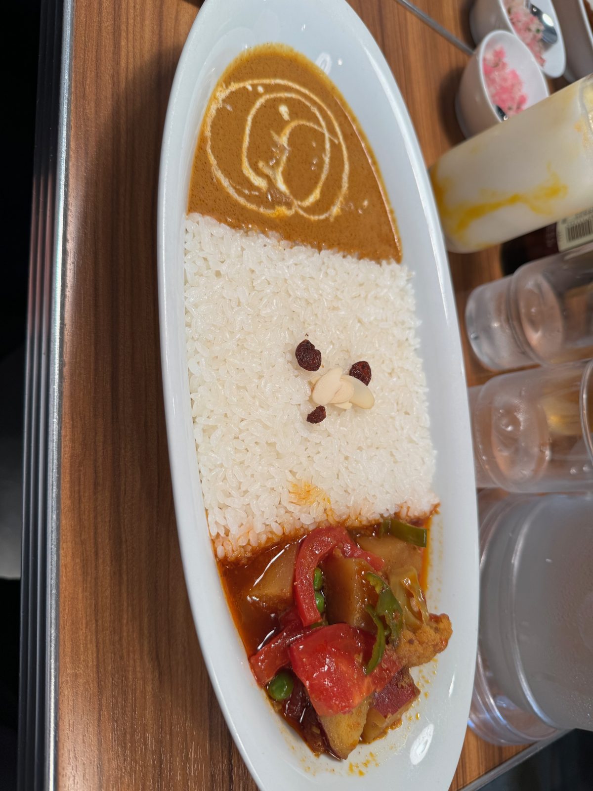 A plate of Japanese soup curry with rice and vegetables on a wood table in Tokyo