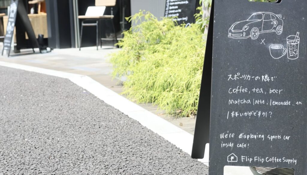 Flip Flip Coffee Supply sidewalk sign in Tokyo reading we are displaying a sports car inside the cafe