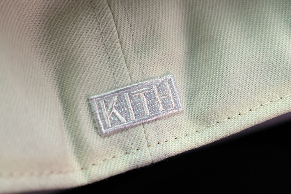 Kith woven side label on the Kith x New Era New York Knicks 59FIFTY fitted cap in Sandrift