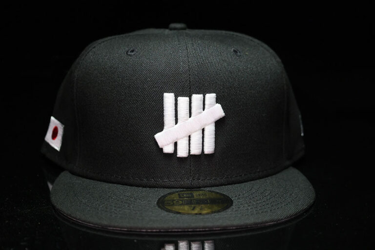 Front of the Undefeated x New Era Icon Fitted cap, black Tokyo colorway with the five-strike logo and Japan flag