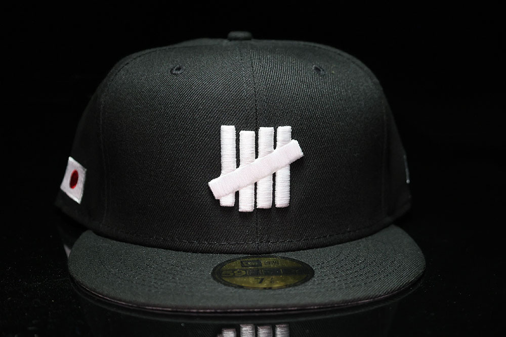 Front of the Undefeated x New Era Icon Fitted cap, black Tokyo colorway with the five-strike logo and Japan flag