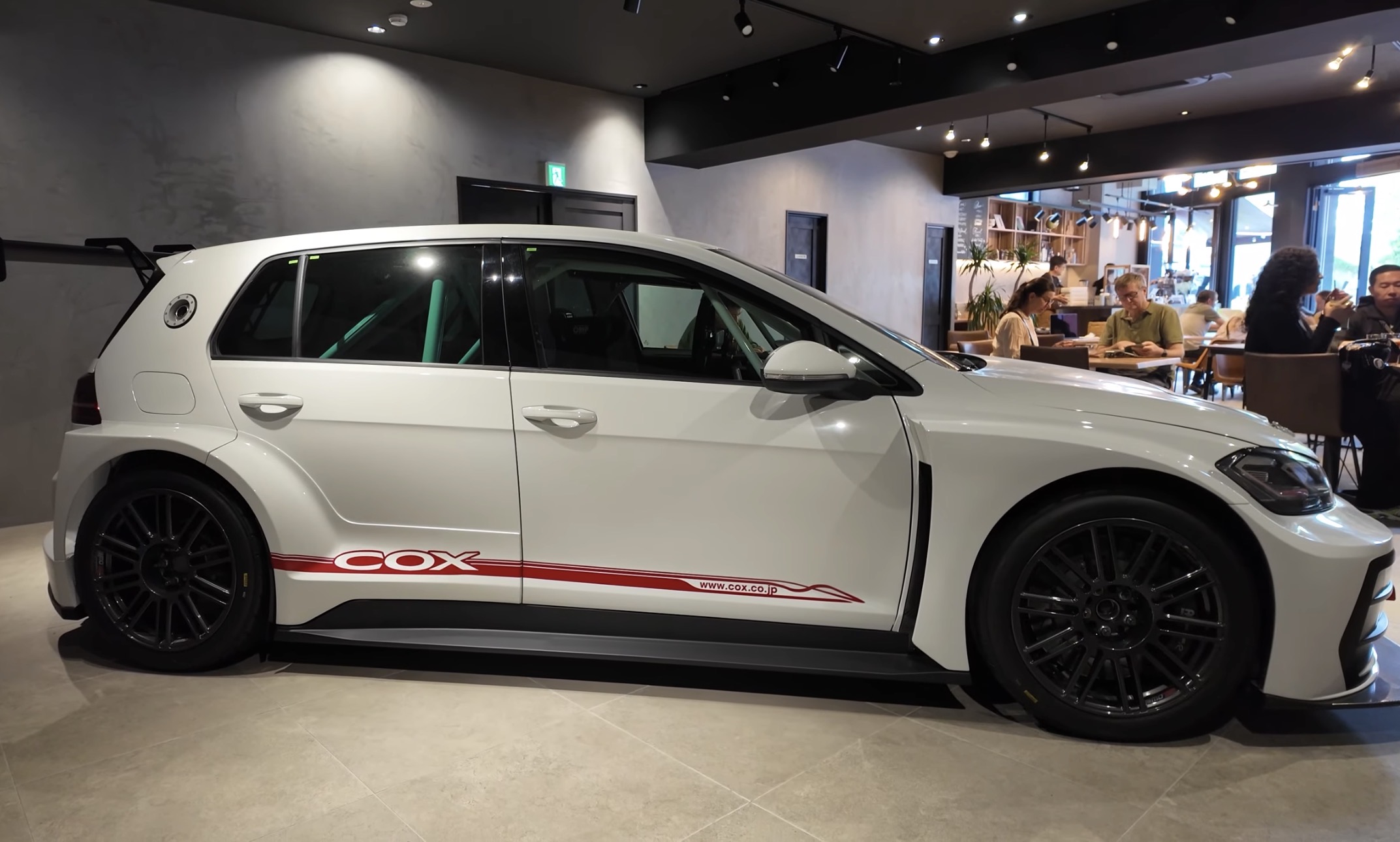 Widebody COX Volkswagen Golf race car parked inside Flip Flip Coffee Supply, a car cafe in Tokyo